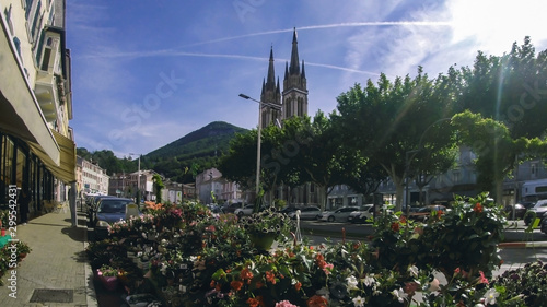 City center with a flower shop in the foreground and the Cathedral in the background. Voiron France