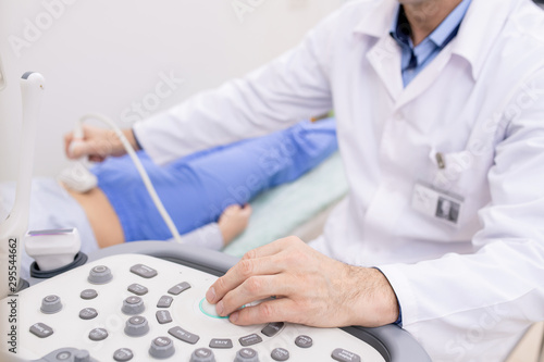 Wallpaper Mural Hand of clinician on panel of ultrasound equipment during examination Torontodigital.ca