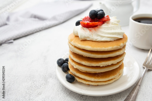 Breakfast wih Pancakes, cream, berry and coffee cup isolated on white background, copy space for text.