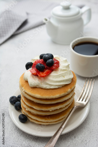 Breakfast wih Pancakes, cream, berry and coffee cup isolated on white background, copy space for text.