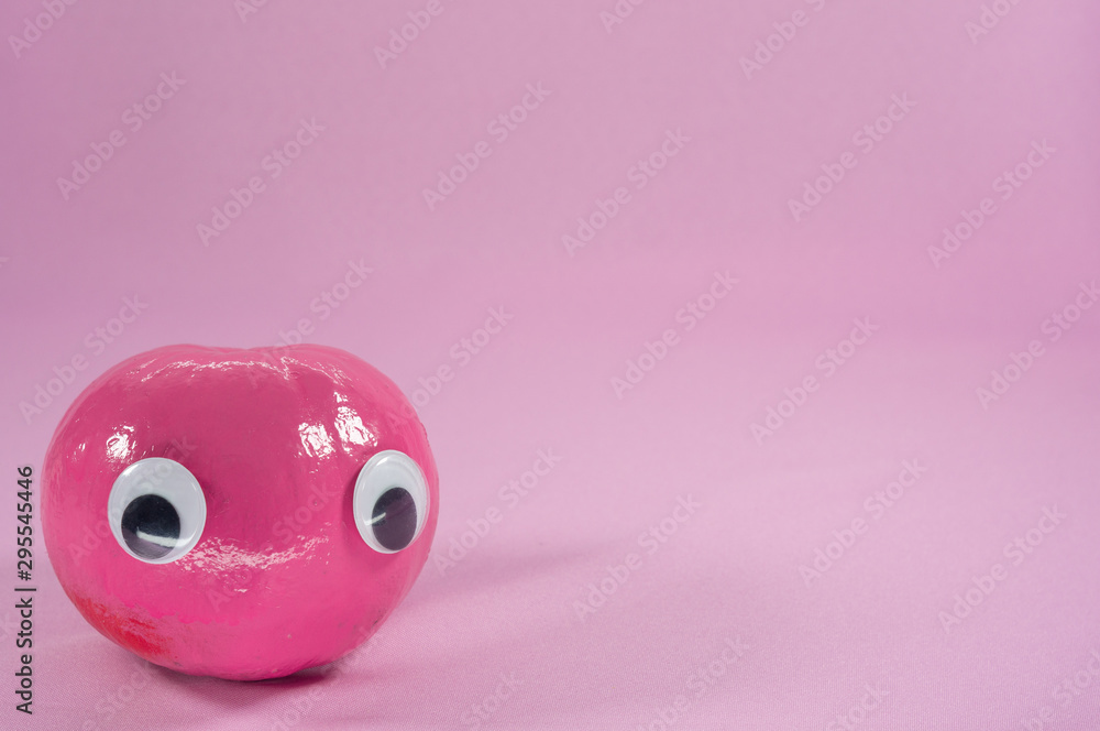 Cute pink pumpkin with googly eyes on pastel pink background with copyspace. Halloween concept Cute pink pumpkin with googly eyes on pastel pink background with copyspace. Halloween concept
