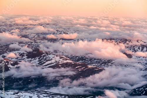 Aerial view of snowy landscape in winter with mountains and lakes in Norway at sunset