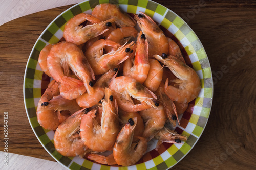boiled shrimp lie on a plate. these shrimp are unpeeled.