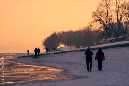 people walking on the beach at sunset