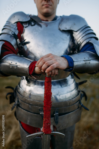 Fotografie, Obraz Medieval knight in metal armor holds sword