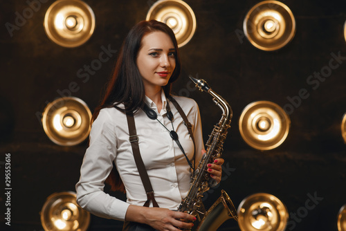 Female saxophonist plays the saxophone on stage photo