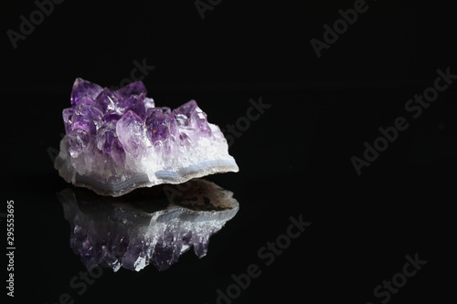 Beautiful purple amethyst gemstone on black background. Space for text
