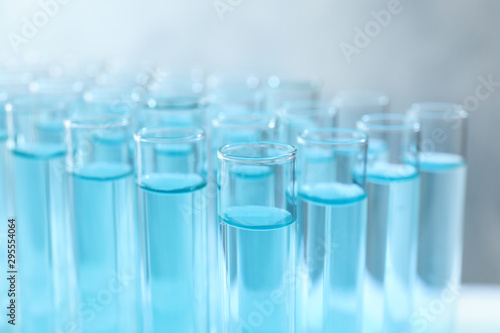 Many test tubes with light blue liquid, closeup