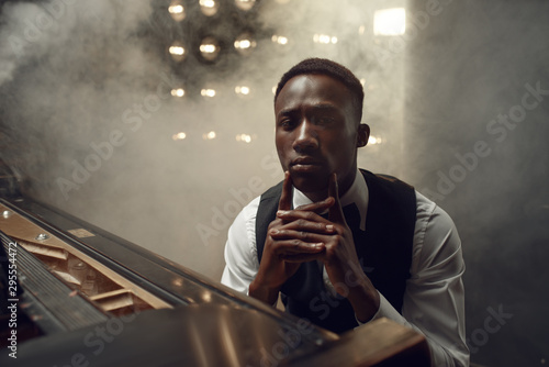 Ebony grand piano musician poses on the stage