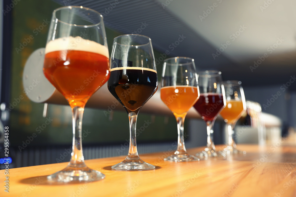 Different sorts of beer on wooden bar counter Different sorts of beer on wooden bar counter