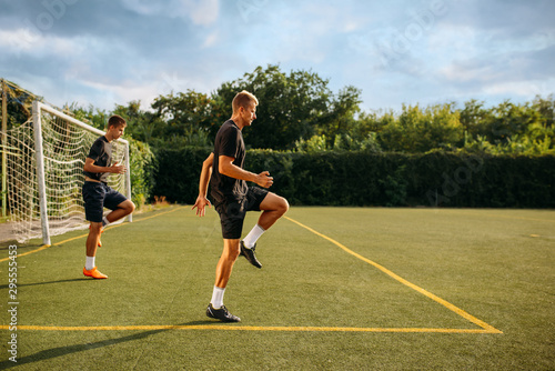Two male soccer players training on the field