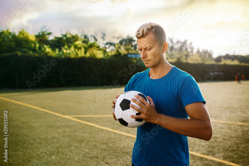 Male soccer player with ball in hands on the field