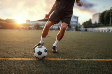 Male football player hits the ball on the field