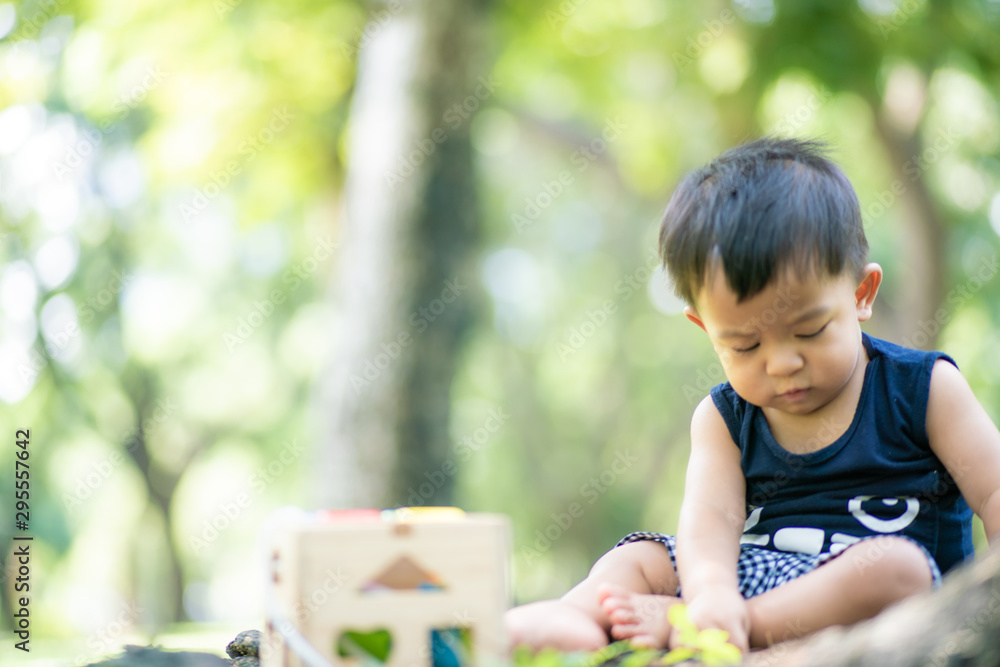 Baby toddler boy playing with toy and nuture in city public park Baby toddler boy playing with toy and nuture in city public park