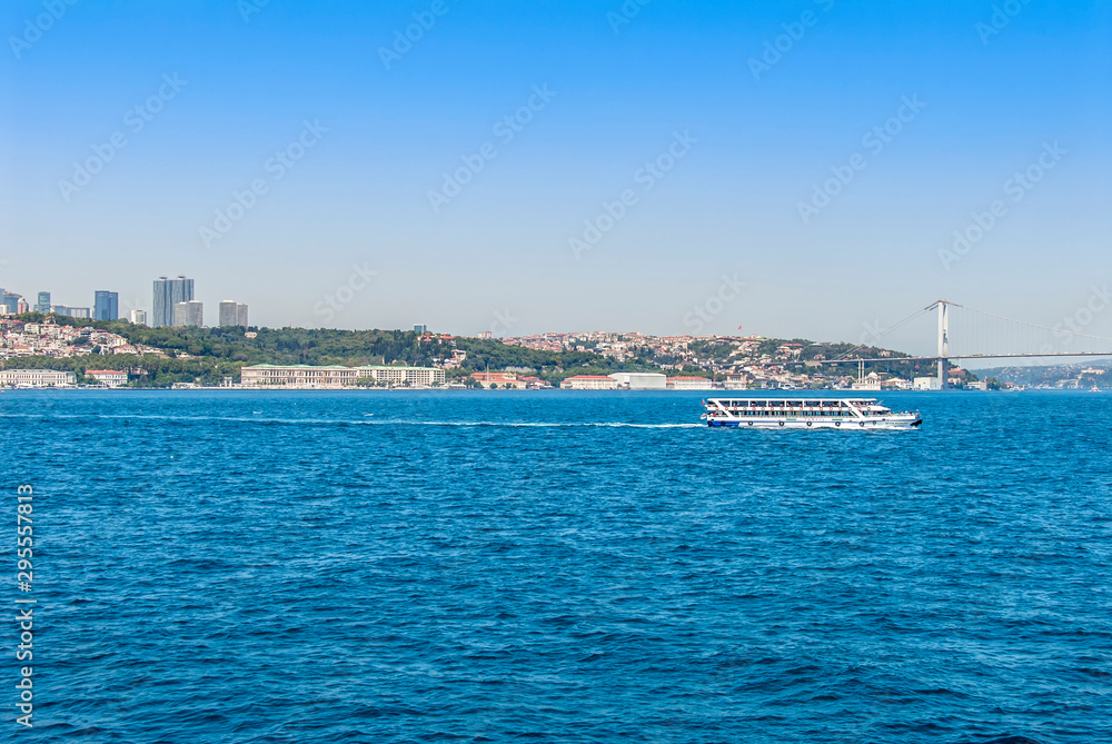 Istanbul, Turkey, 29 June 2019: Ciragan Palace, Towers, Bridge, and Ship, Bosphorus.