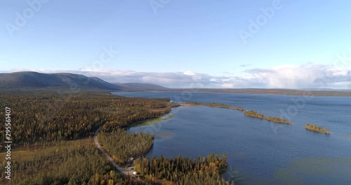 Lapland lake, Aerial, drone shot, towards pallasjarvi, overlooking fall color trees, islands and pallastunturi fells in the background, on a sunny, fall day, in Pallas-Yllas national park, Finland photo