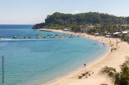 Sea, blue sky, palms, tourists and boats in White beach, Sabang. © aldarinho