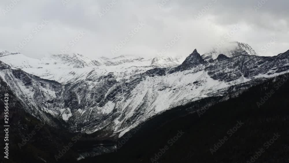 Aerial view of Glacier National Park, breathtaking landscapes of Montana, snowy mountain peaks and endless green forest, moody shoots of nature Aerial view of Glacier National Park, breathtaking landscapes of Montana, snowy mountain peaks and endless green forest, moody shoots of nature
