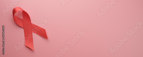 Red ribbon on pink background with copy space, banner concept.