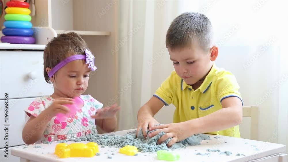 Boy and girl in the nursery at the table playing with kinetic sand HD 1080 Boy and girl in the nursery at the table playing with kinetic sand HD 1080