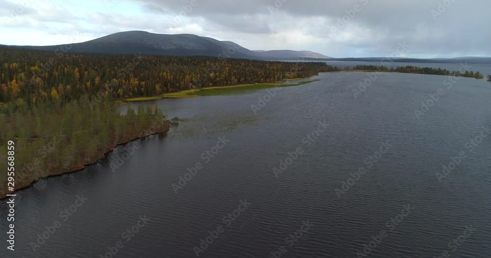Pallasjarvi, Aerial, tracking, drone shot, over a arctic lake, overlooking autumn forest and the Ounastunturit fells, on a dark, fall day, in Pallas-Yllas national park, Lapland, Finland Pallasjarvi, Aerial, tracking, drone shot, over a arctic lake, overlooking autumn forest and the Ounastunturit fells, on a dark, fall day, in Pallas-Yllas national park, Lapland, Finland