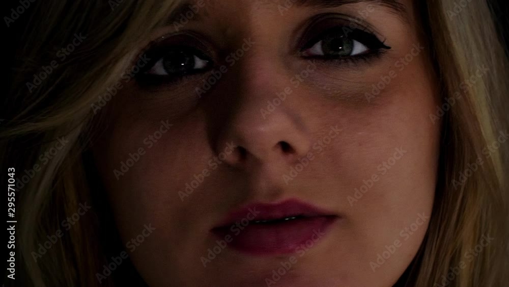 Young woman makes many silly expressions to camera; close up; low key lighting. Young woman makes many silly expressions to camera; close up; low key lighting.
