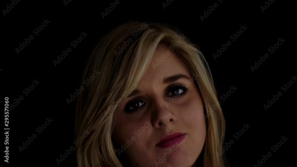 Young charming woman making expressions to camera and dancing; low key lighting. Young charming woman making expressions to camera and dancing; low key lighting.