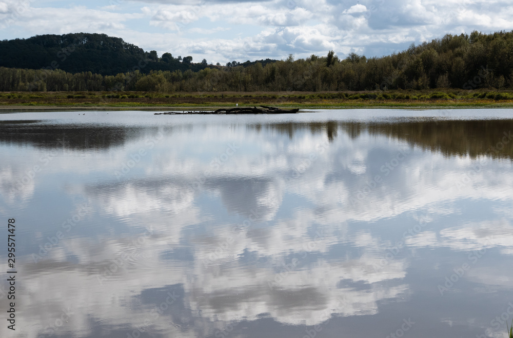 Clouds reflecting on a clear lake with hills Clouds reflecting on a clear lake with hills