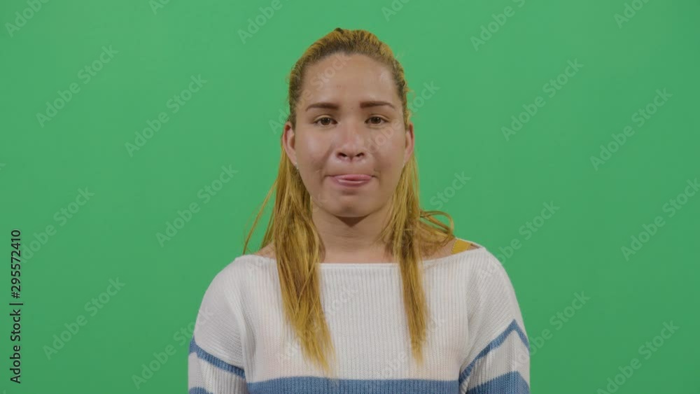 Woman Licking Lips At The Viewer Expressing Desire Or The Taste Of Some Delicious Food. Studio Isolated Shot Against Green Screen Background
