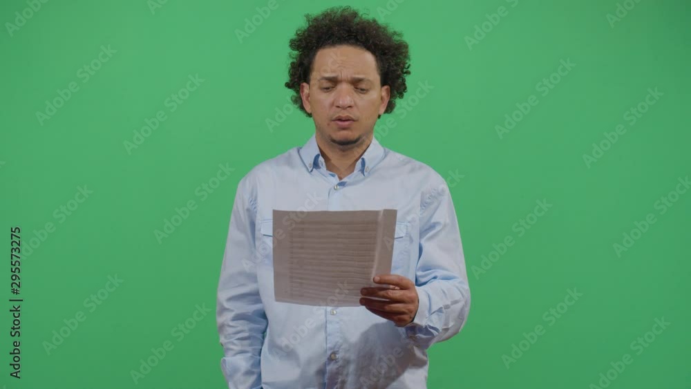 Adult Man Holding A Paper And Reading The Text On It Outloud. Studio Isolated Shot Against Green Screen Background Adult Man Holding A Paper And Reading The Text On It Outloud. Studio Isolated Shot Against Green Screen Background