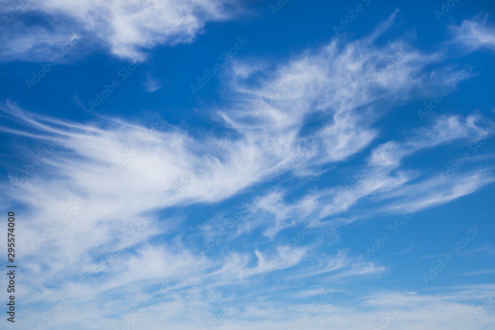Blue sky and white beautiful clouds. Background. Wallpaper for the walls.