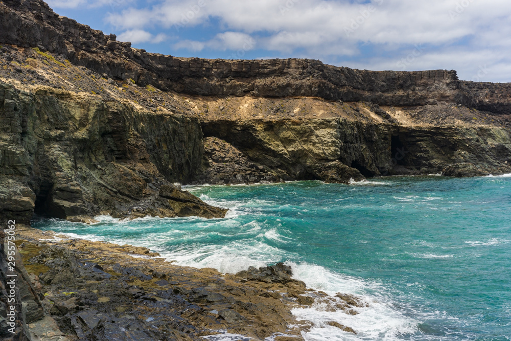 a rocky coastline with blue water on the canary island fuerteventura