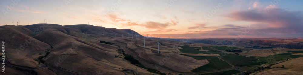 Beautiful Aerial Panoramic Landscape View of Wind Turbines on a Windy Hill during a colorful sunrise. Taken in Washington State, United States of America.