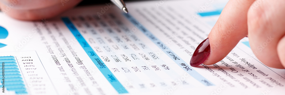 Female arm hold and point silver pen in financial graph