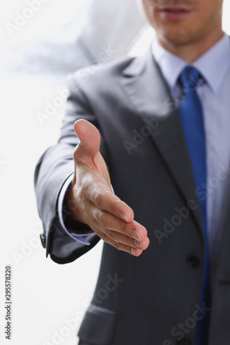 Man in suit and tie give hand as hello