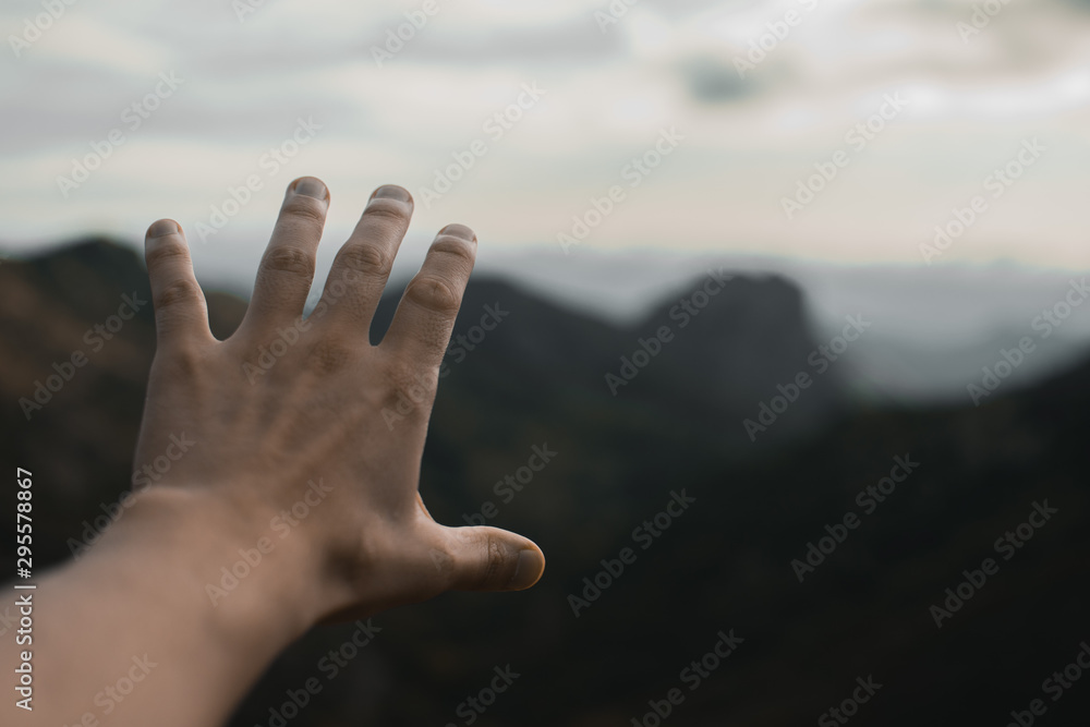 Opened hand with a mountain at the background Opened hand with a mountain at the background