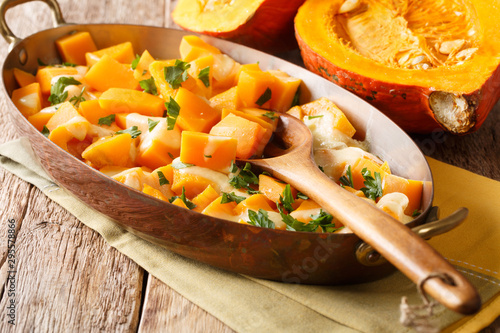 Autumn pumpkin casserole with mozzarella cheese and herbs close-up in a baking dish. horizontal