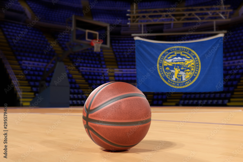 Naklejka premium Nebraska state flag and basketball on Court Floor