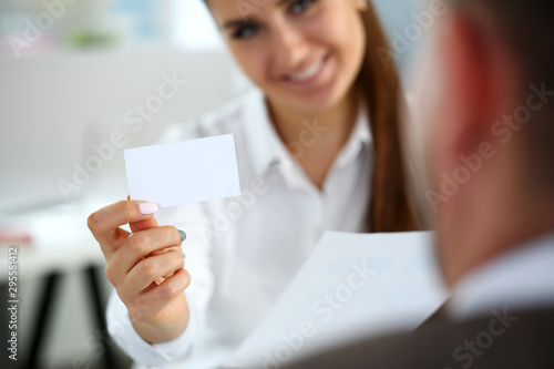 Female arm in suit give blank calling card to visitor closeup. White collar colleagues company name exchange job interview sale clerk id executive or ceo finance support formal identity concept