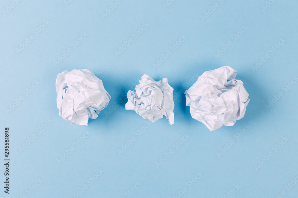 Crumpled paper balls, waste and recycling concept on blue background Crumpled paper balls, waste and recycling concept on blue background