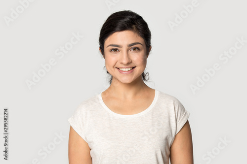 Headshot portrait of smiling indian girl posing in studio
