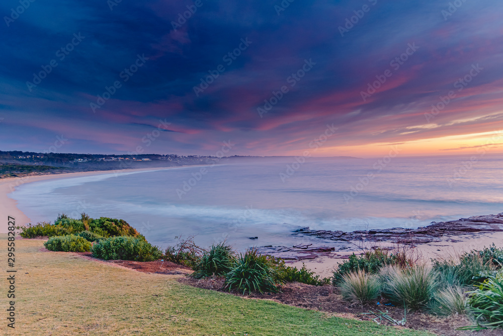 Obraz premium Colourful Sunrise Seascape with Heavy Clouds Blanketing the Sky