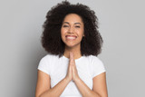 Happy biracial young woman with hands in prayer feel thankful