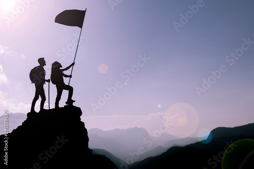 friend holding flag on top mountain. Conception of winner, success and leadership