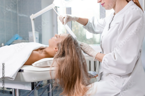Фотография Beautiful girl at the reception of a dermatologist in the health clinic