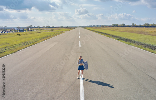 girl on a motorcycle race with starting flags photo