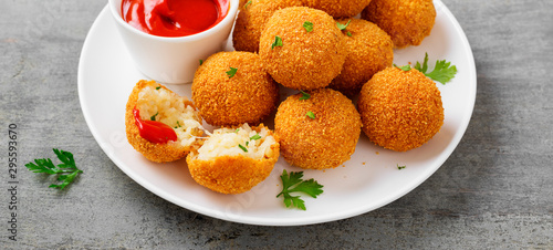 Homemade Fried Risotto Arancini stuffed with cheese, served with tomato sauce.