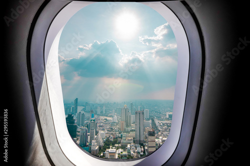 Airplane window view of Bangkok city with blue sky. Concept of travel and air transportation