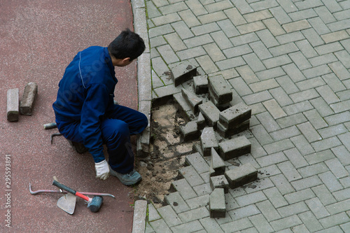 Repair pavement. Worker mason shifts the pavement