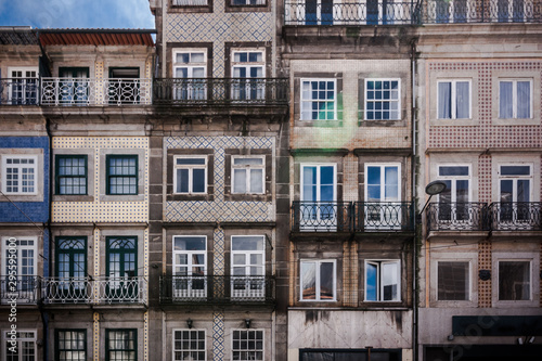 Historic old city buildings with portuguese tiles on the facade in Porto. Front view of typical portugal houses with balconies